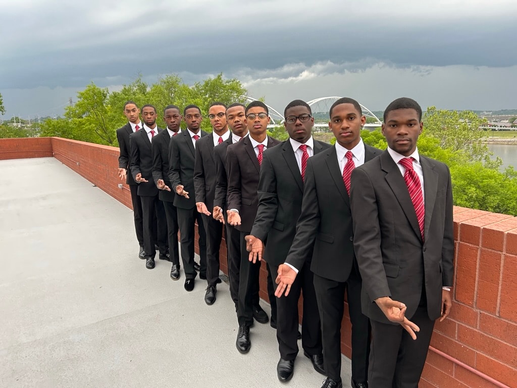 Brothers lined up in black suits on rooftop